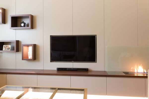 An open fireplace built into a fitted media wall