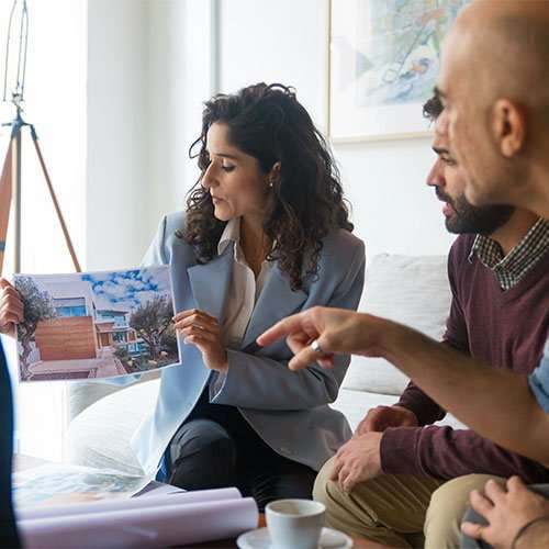 A designer going through plans with clients in their home