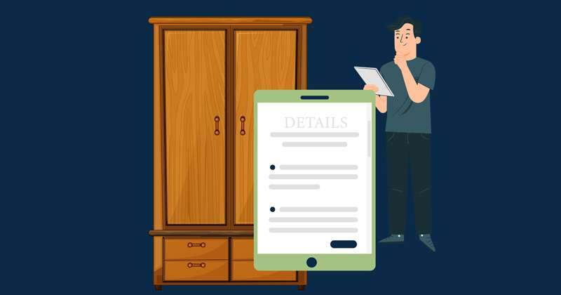 A joiner with a tablet taking notes in front of a fitted wardrobe