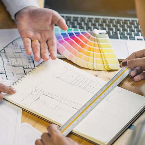 A colour fan held over a technical drawing during a design visit
