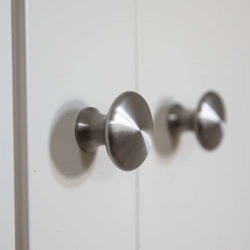 Brushed steel knobs on a painted cabinet door