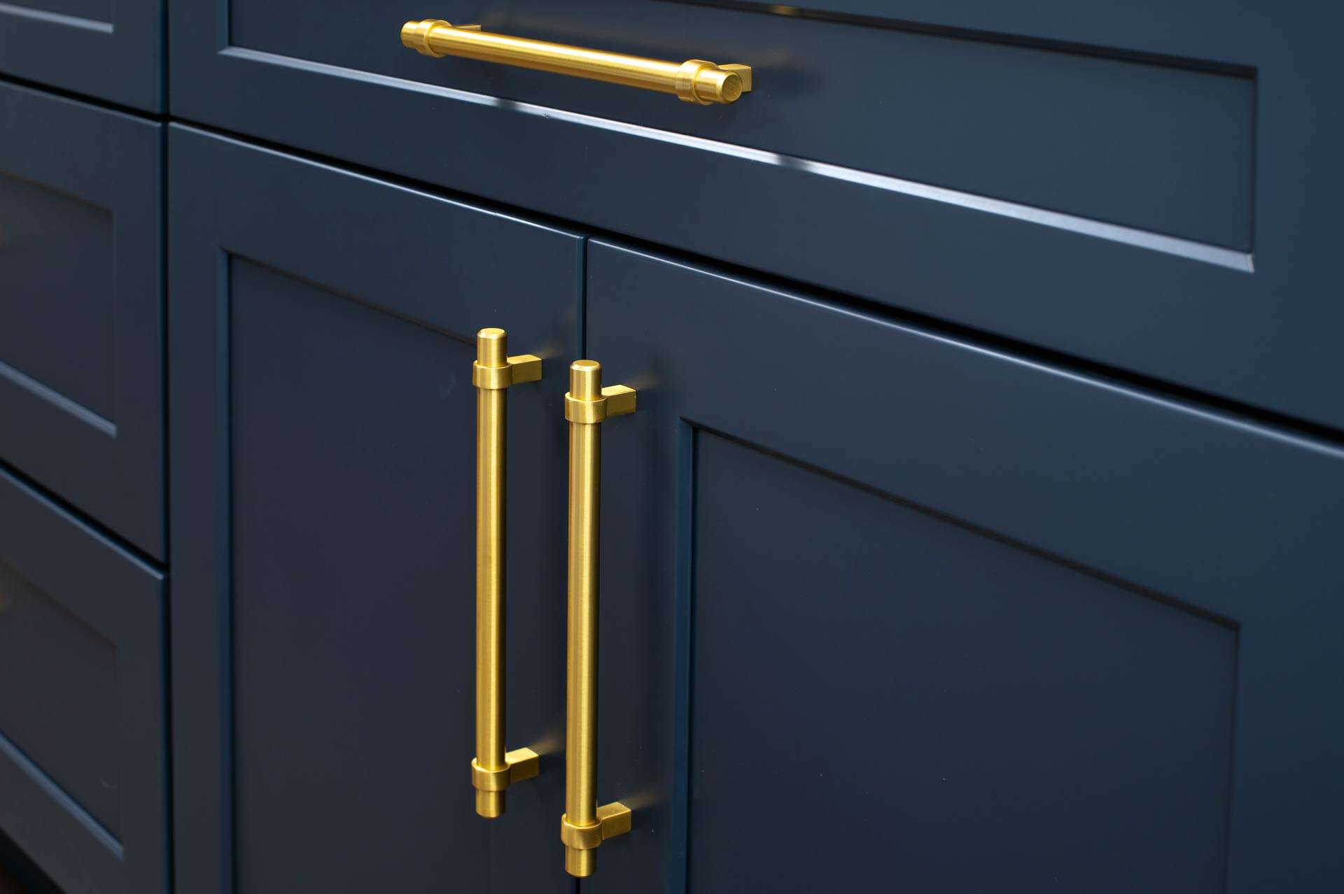 Bespoke navy cabinetry with brass handles by Befilo
