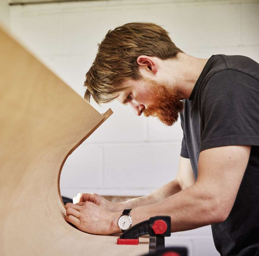 A joiner measuring a bespoke unit on site